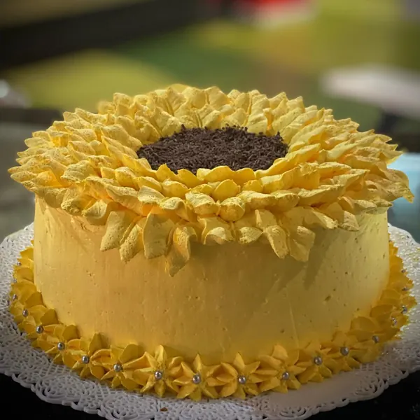 Torta amarilla decorada como un girasol con centro de chocolate